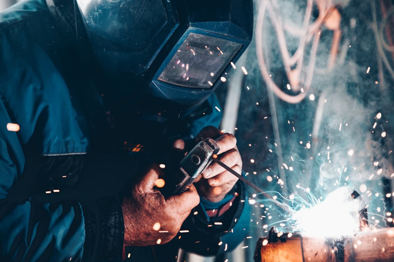 Soldador em atividade com equipamento de proteção em ambiente industrial
