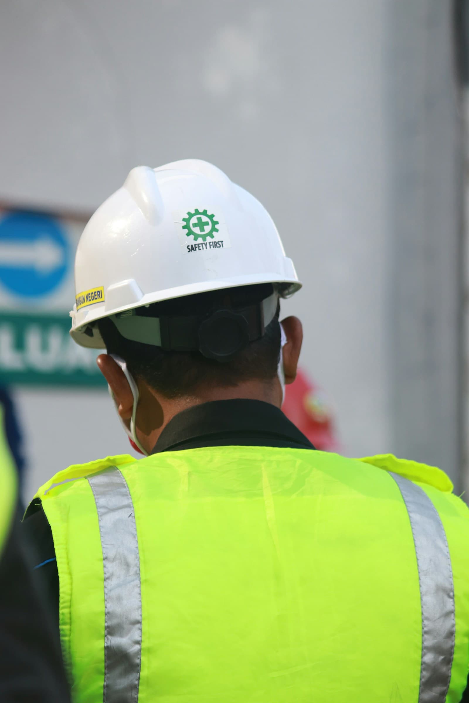 Trabalhador com colete refletivo e capacete branco em obra