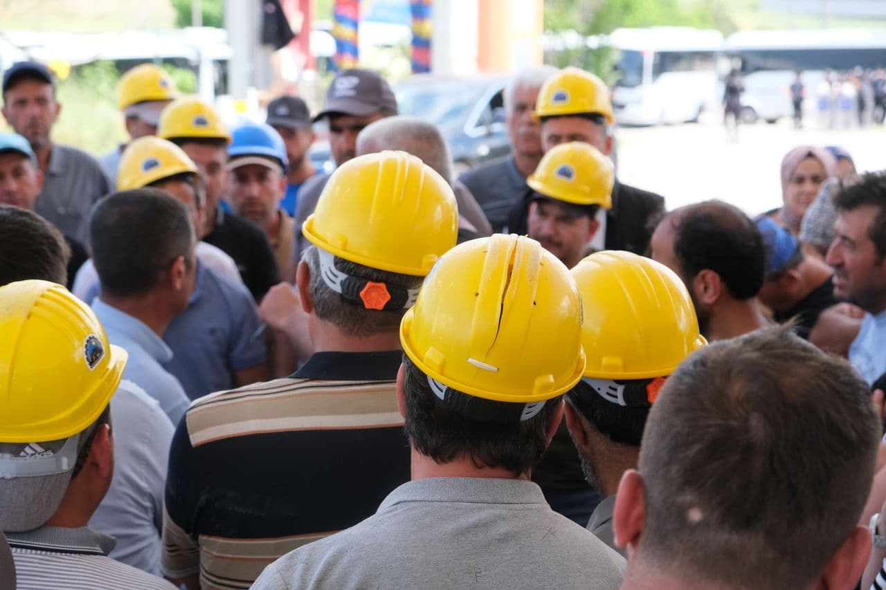 Equipe de trabalhadores com capacetes amarelos em canteiro de obras